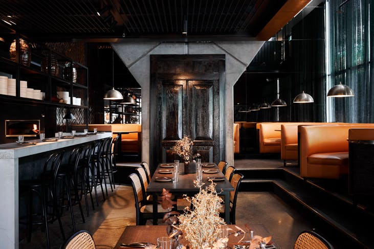 The sleek black and orange-hued interior at Wilma restaurant in Canberra.